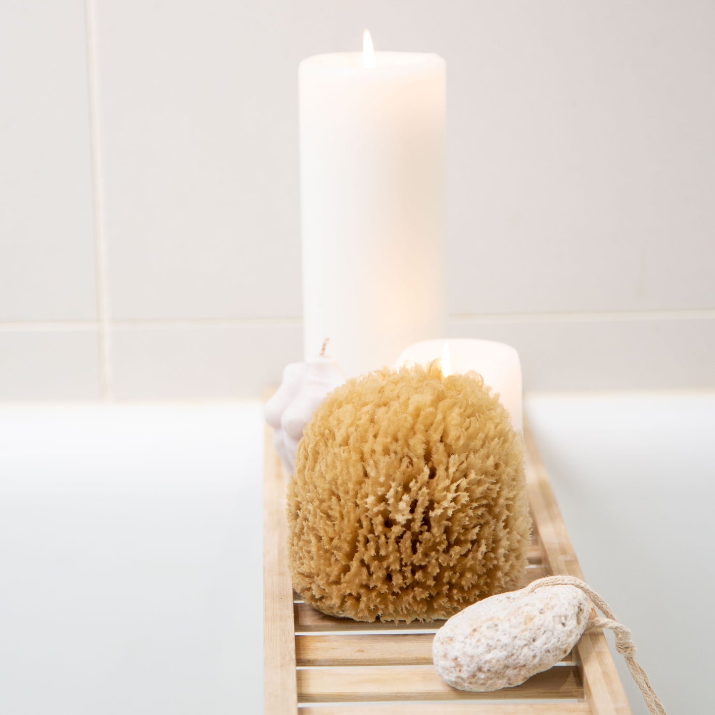 Naroa exfoliate real sea sponge on a wooden rack over a bath
