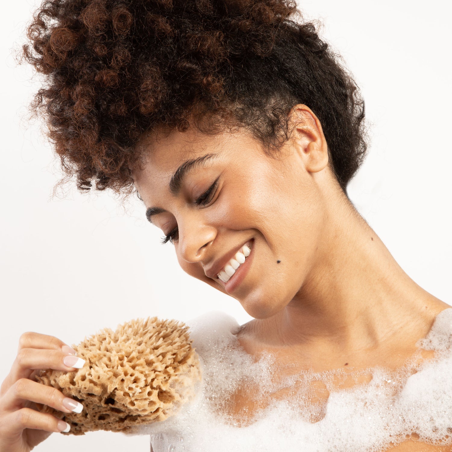 Woman holding sponge on shoulder with lather