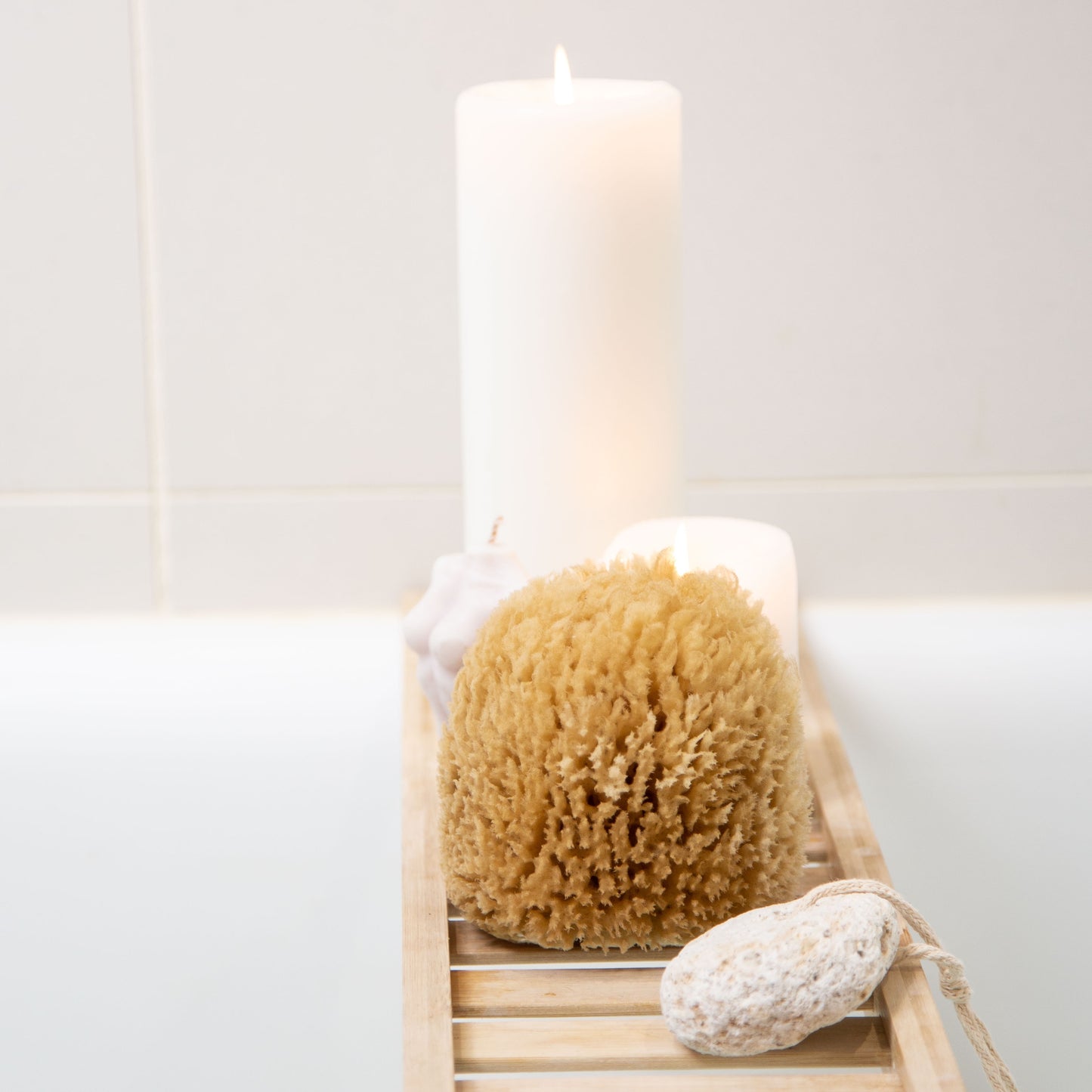 Naroa exfoliate real sea sponge on a wooden rack over a bath 